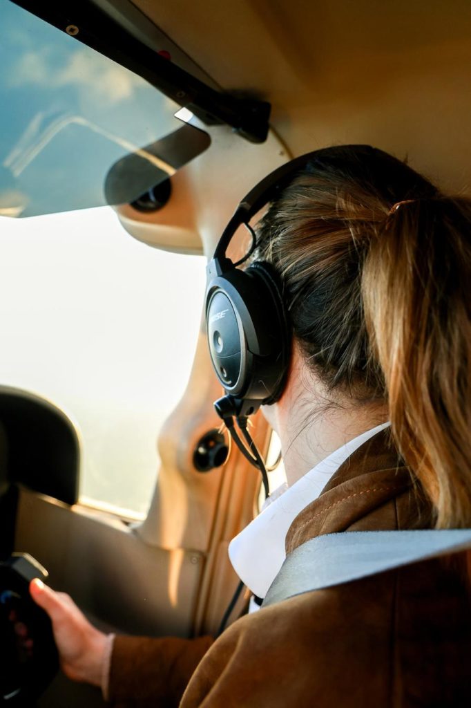 Female student pilot close up of side profile looking out window showing Bose headset