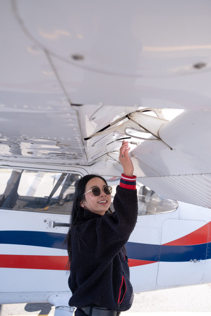 Female student preflighting cessna 172 for solo flight