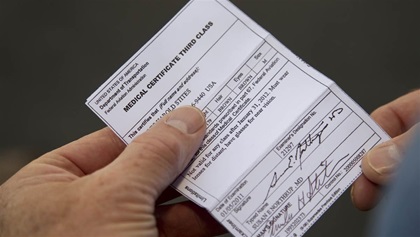 Man holding a third class medical certificate