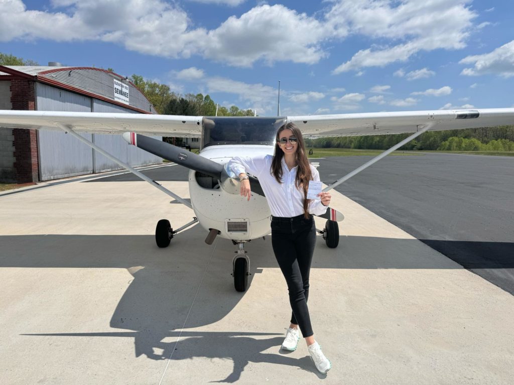 female student standing in front of Cessna 172