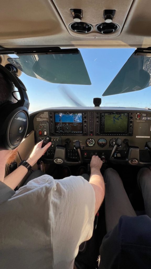 student wearing bose headset flying with instructor in Cessna 172 with G1000 avionics display