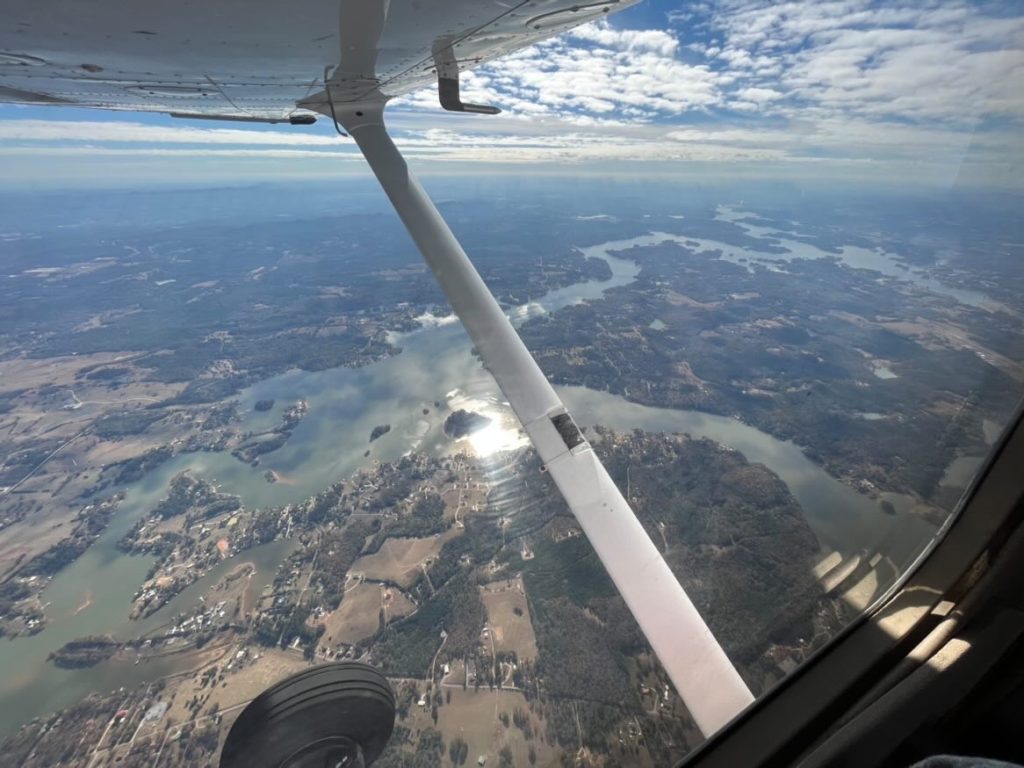 wing view of ground from a Cessna 172 plane