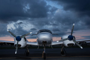 diamond da42 twinstar multi engine aircraft front view with dark clouds in the background