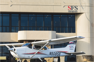 red white and blue Cessna 172 airplane outside of sfs flight training facility
